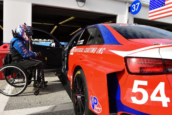 Michael in his wheelchair beside the #54 Audi TCR in the garage, 2018