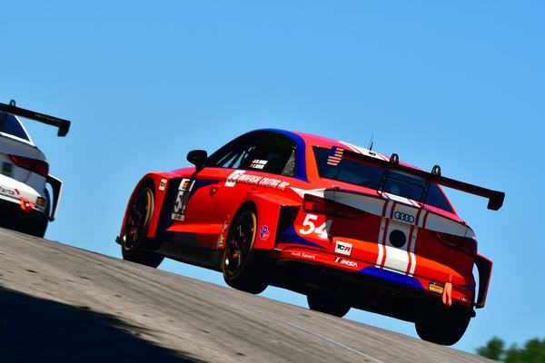 The #54 Audi cresting a rise with a wheel in the air, 2018