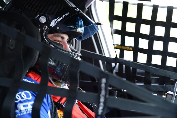 Michael, helmeted, in the cockpit behind the window net, 2018