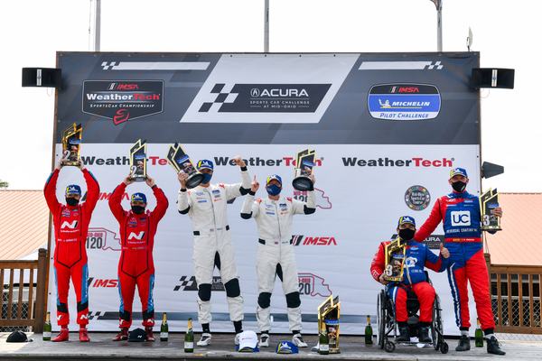 Podium celebration with Michael in his wheelchair, 2020