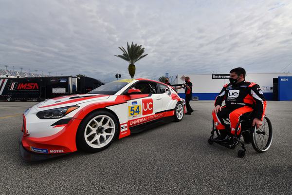 Michael in his wheelchair beside the #54 Hyundai Veloster N, 2021