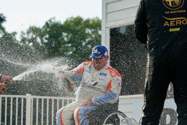 Michael spraying champagne from his wheelchair, 2022